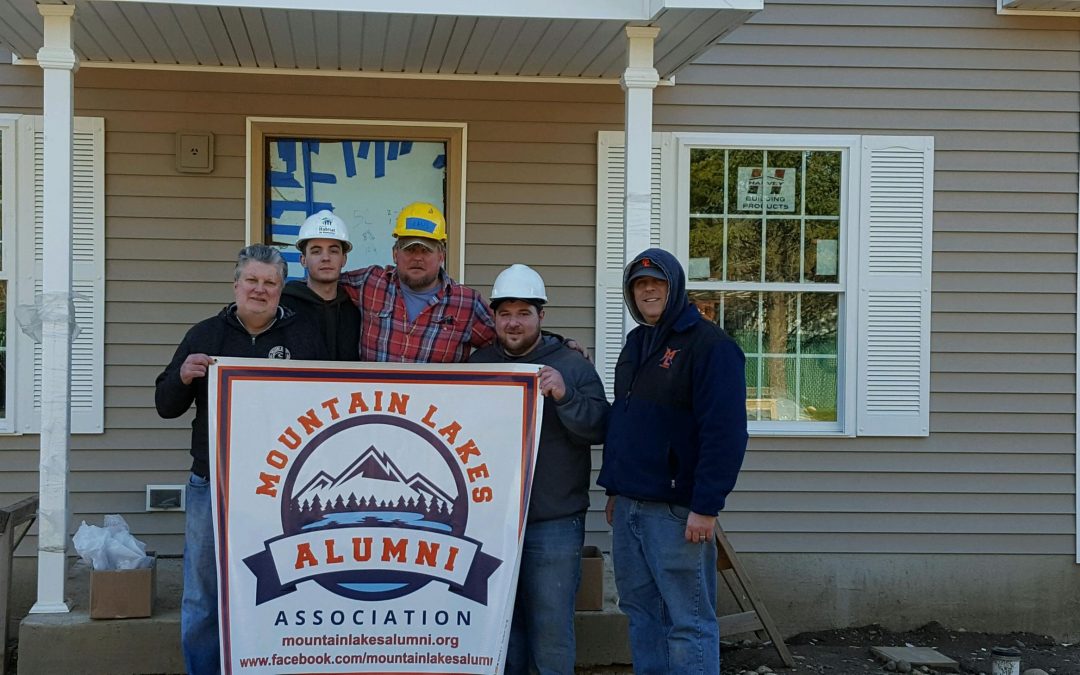 MLAA Board members stand in front of a home they helped build with Habitat for Humanity.