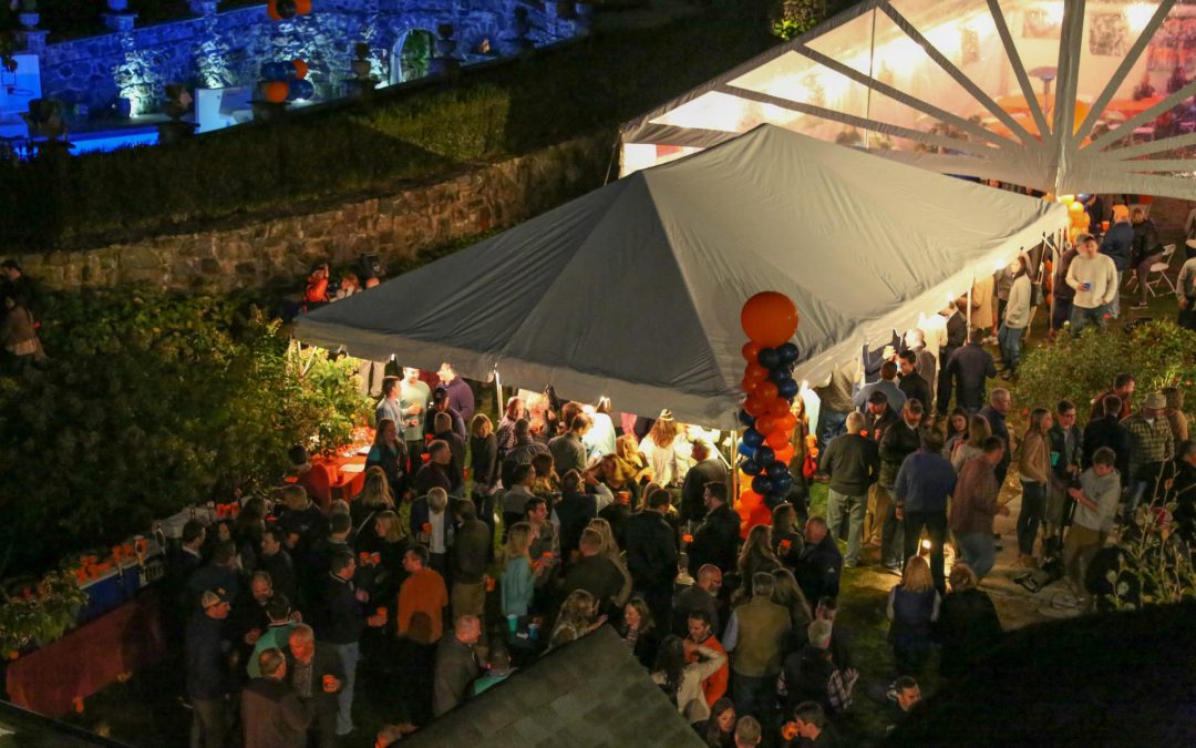 Elevated view of a party tent with partiers all around.