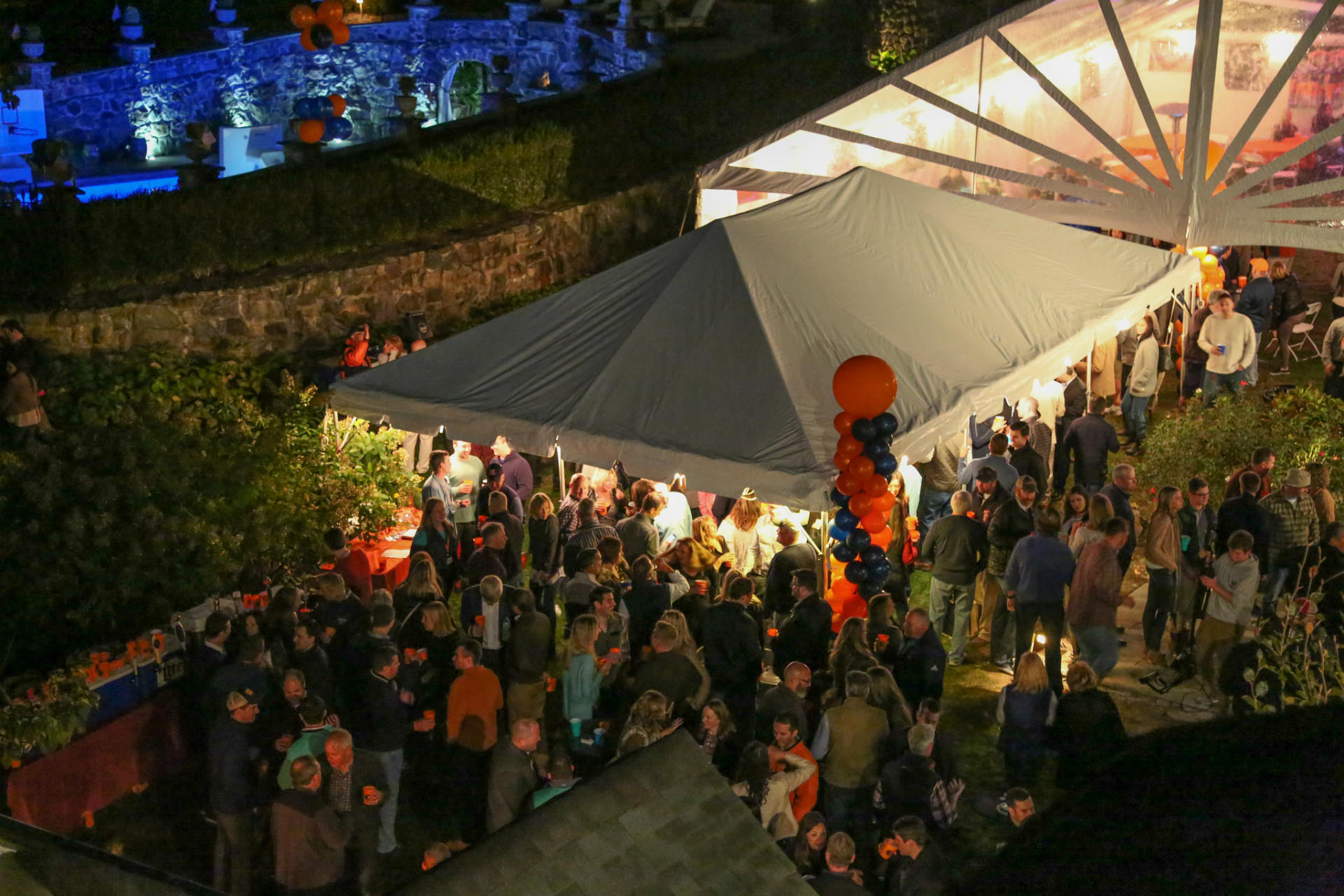 Elevated view of a party tent with partiers all around.