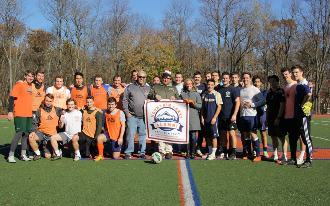 MLAA reps and alumni players pose on the field following the 2017 Mountain Lakes Alumni soccer game.
